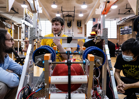 Students and teacher work on a machine