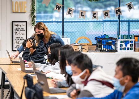 Teacher with elementary students at computers