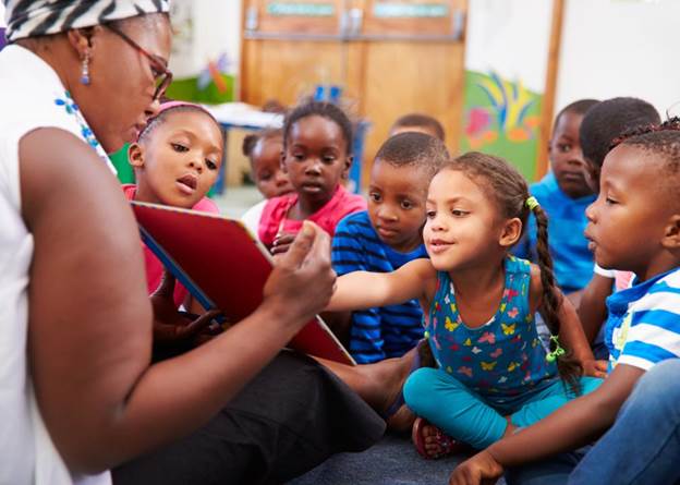 Children sitting with their elementary school teacher