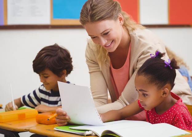 Primary education teacher sitting with students