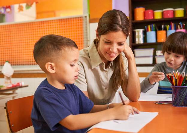 Teacher and student work together in elementary school class