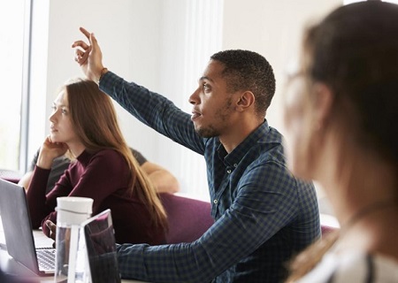 College student raising his hand in class